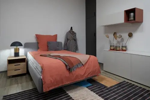 Modern eingerichtetes Schlafzimmer mit gemütlichem Bett, Nachttisch und stilvoller Dekoration.