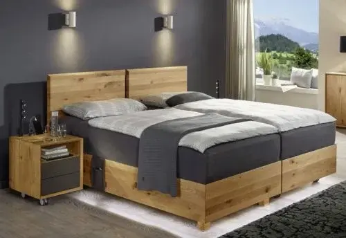Modernes Schlafzimmer mit Massivholz-Bett, Nachttisch und Blick auf die Berge.
